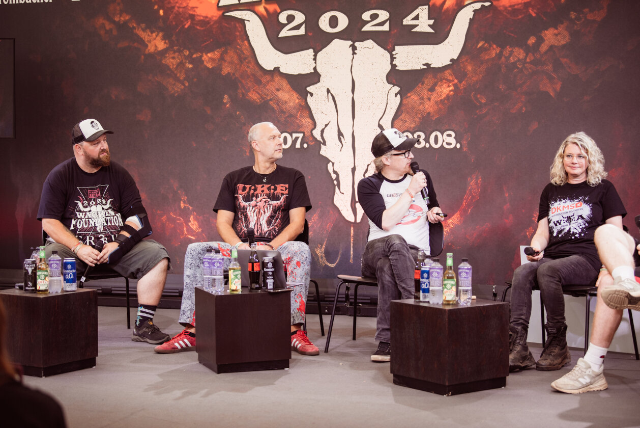 Korn, Amon Amarth, The 69 Eyes, Testament, Behemoth, Gene Simmons, Blind Guardian und ein bisschen Wacken-Schlamm. – DKMS-Panel.